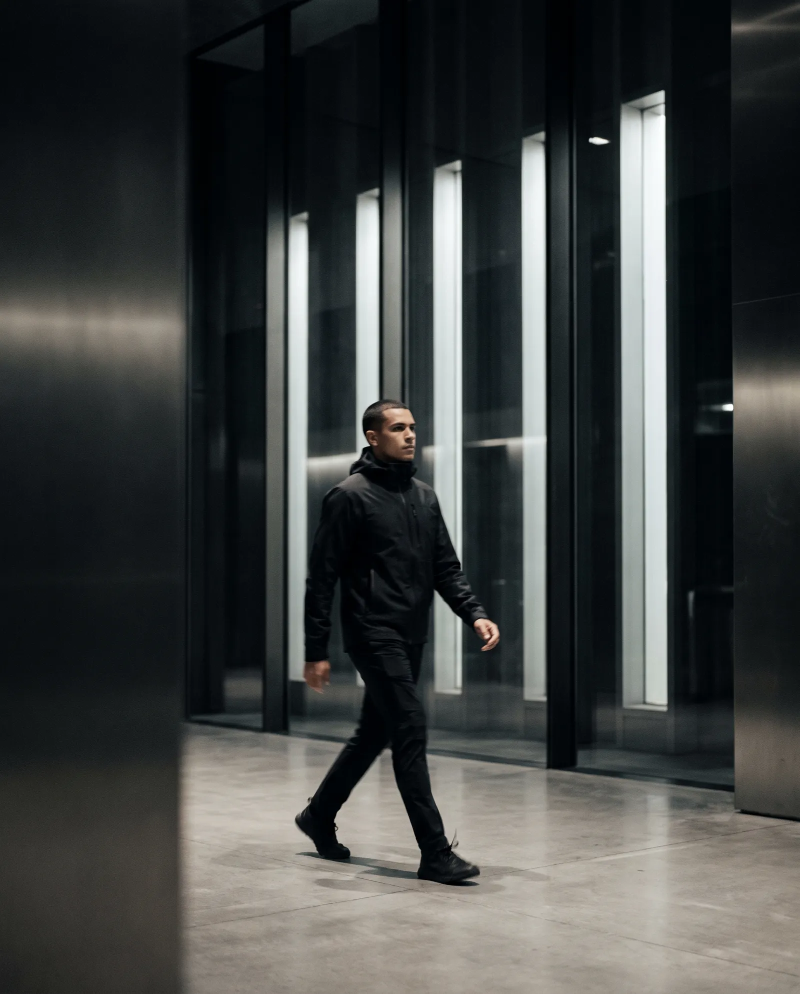 Fundador caminhando em arquitetura de concreto e vidro